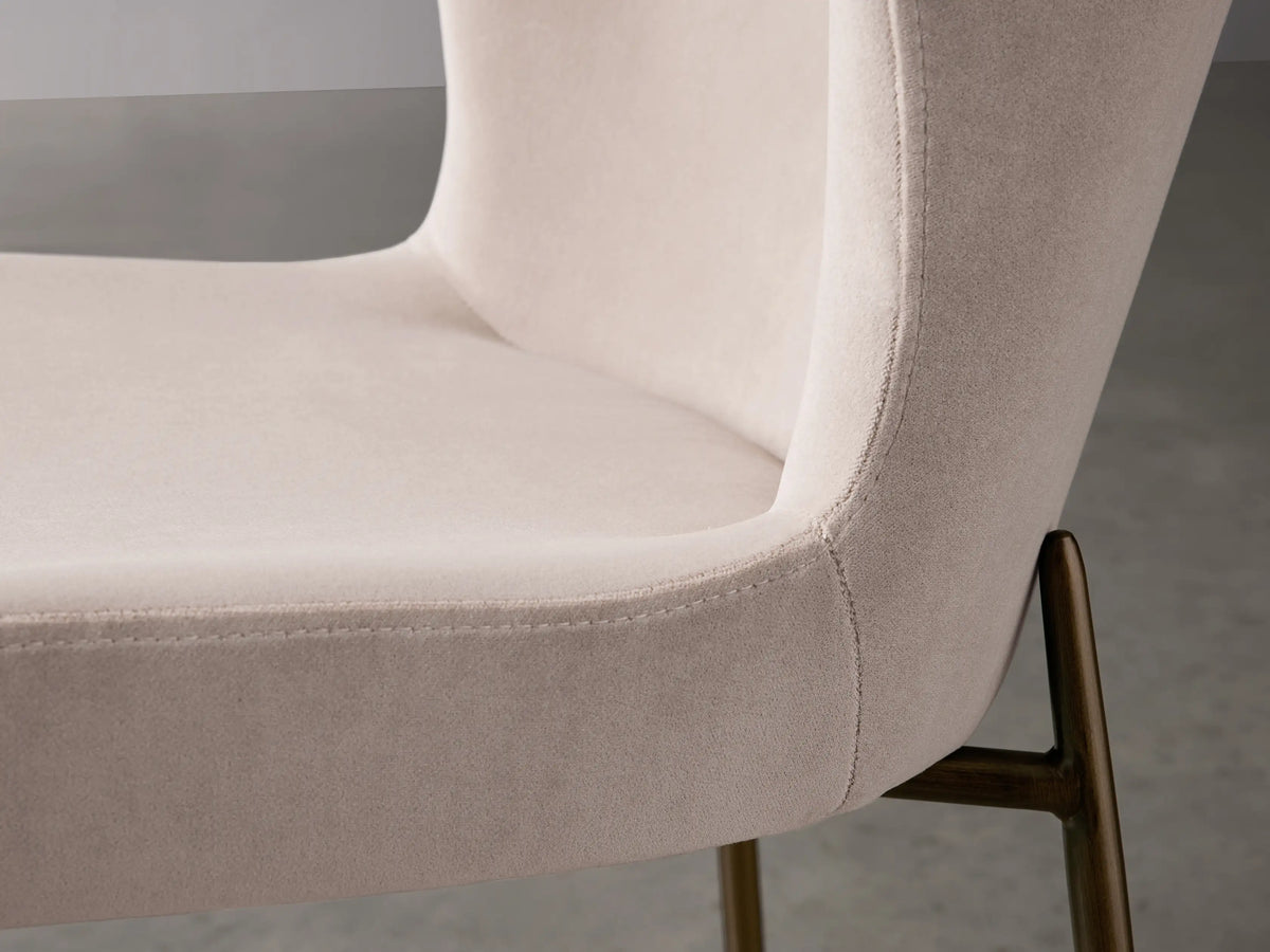 Kirsten Dining Chair in Vanni Linen, featuring a soft beige fabric seat with a curved backrest and slim, powder-coated iron legs.
