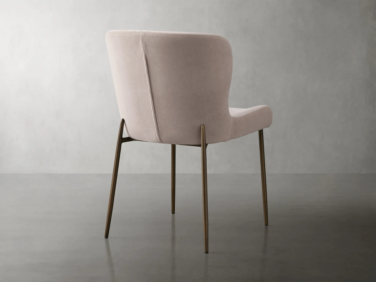 Kirsten Dining Chair in Vanni Linen, featuring a soft beige fabric with curved backrest and iron legs with a textured finish.