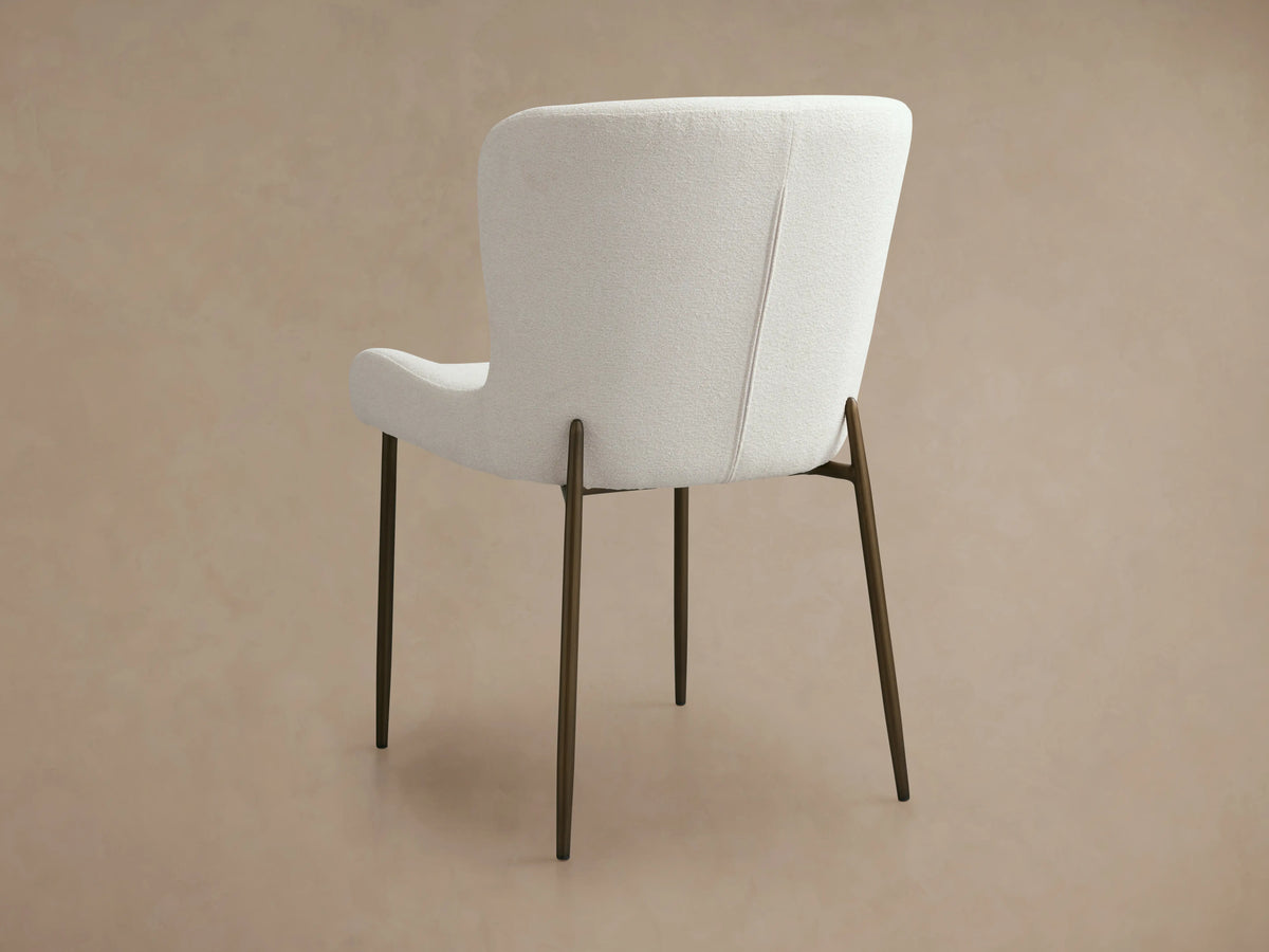 Kirsten Dining Chair with a white upholstered curved backrest, iron legs in a powder-coated finish, shown from the back.