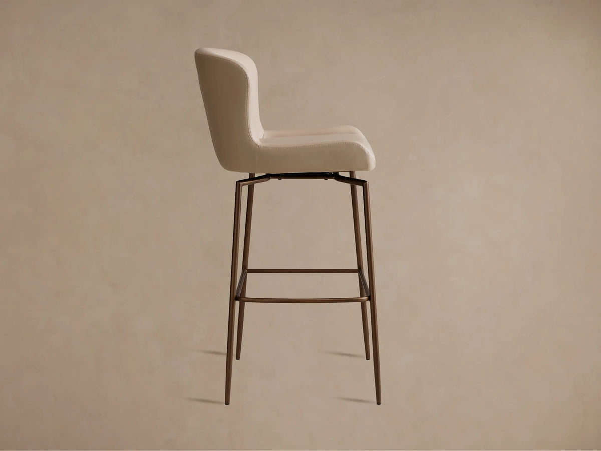Kirsten Faux Leather Swivel Stool in beige, close-up view showing smooth curved backrest and stitched detailing on faux leather.