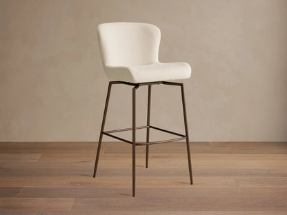 Kirsten Swivel Stool with cream upholstered backrest and seat, set on dark iron legs with a swivel mechanism.