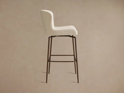 Kirsten Swivel Stool with white upholstered seat, curved backrest, and powder-coated iron legs in a brown finish, viewed from an angle.