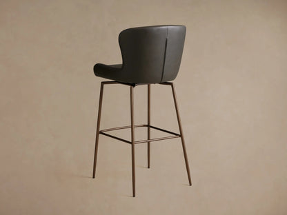Kirsten Faux Leather Swivel Stool side view showing a dark faux leather seat and back with slender, powder-coated iron legs.