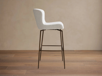 Kirsten Swivel Stool with cream fabric seat and curved backrest, metal frame and legs with a dark powder-coated finish.