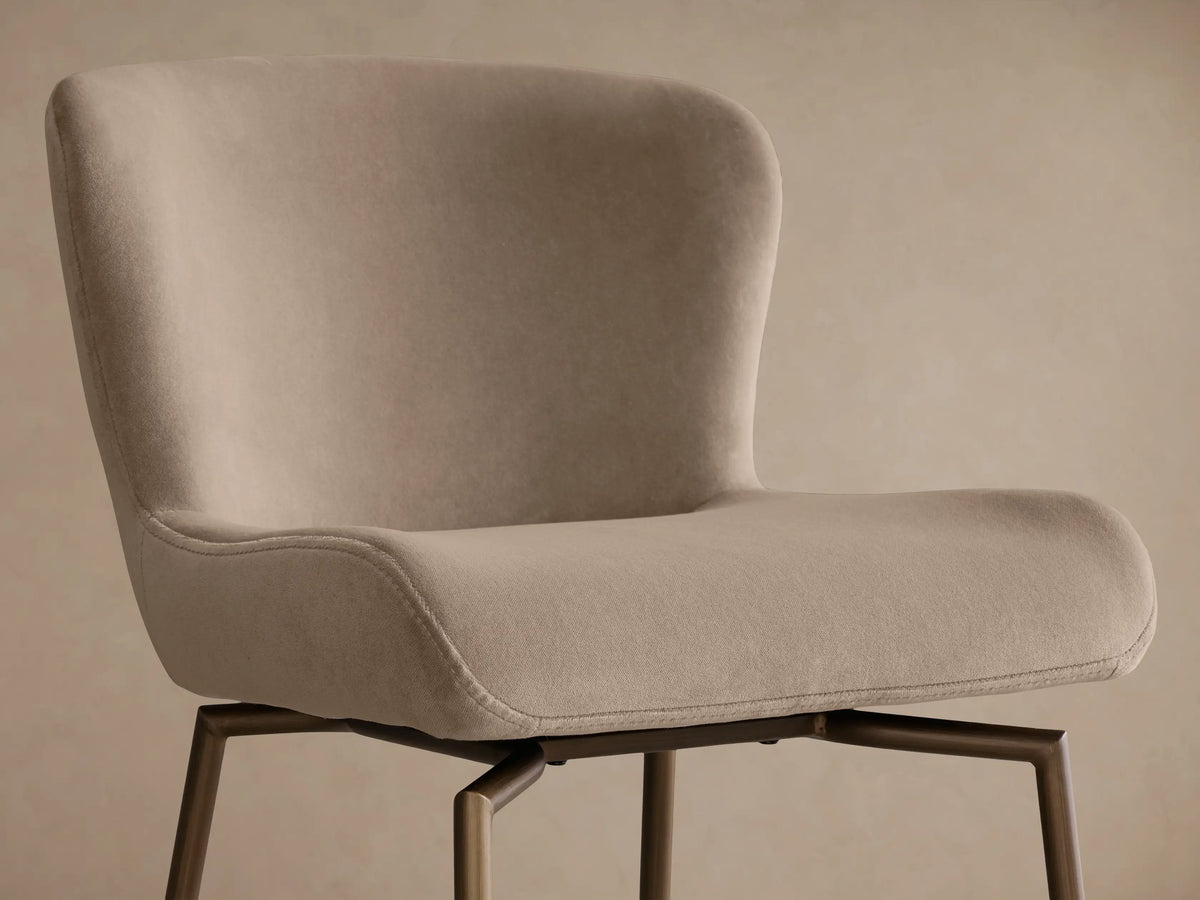 Front view of the beige upholstered Kirsten Swivel Stool with a bronze powder-coated iron frame.