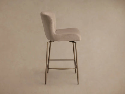 Rear view of the beige Kirsten Swivel Stool with a curved upholstered back and seat, supported by powder-coated bronze metal legs.