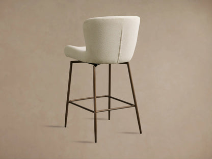 Kirsten Swivel Stool with light textured fabric upholstery, showcasing curved backrest and seat on slender metal legs.