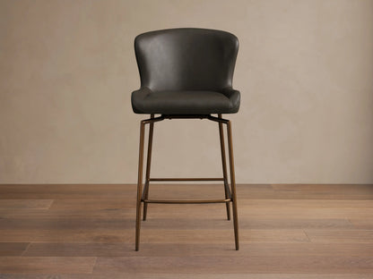 Kirsten Faux Leather Swivel Stool with dark faux leather seat, curved backrest, and slender iron legs, viewed from the side.