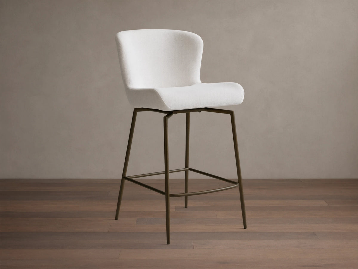 Kirsten Swivel Stool with white cushioned seat, curved backrest, and black powder-coated iron frame on wooden floor.