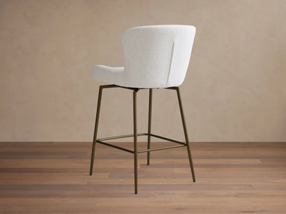 Kirsten Swivel Stool with a white upholstered curved seat and backrest. Features black powder-coated iron legs. Beige background.