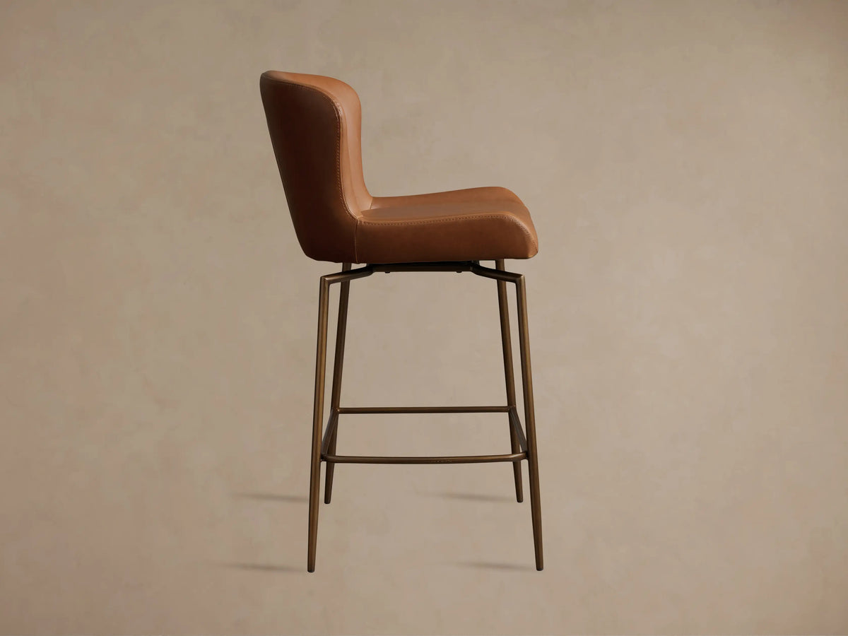 Brown Kirsten Faux Leather Swivel Stool with high backrest, iron frame, and legs; shown in side view on a neutral background.