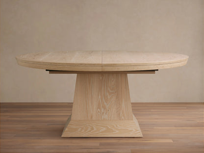 Leighton Extension Dining Table: oval, light blonde oak veneer top with visible grain and center seam, on a wide pedestal base.