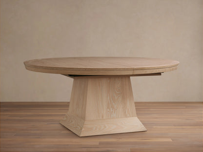 Light oak oval Leighton Extension Dining Table set with dinnerware in a stylish dining room with arch mirrors.
