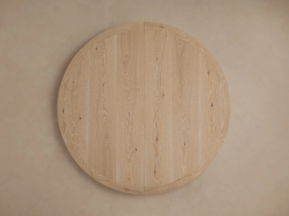 Angled close-up of Leighton Extension Dining Table's light oak veneer surface with visible grain, rounded edge & a subtle seam.