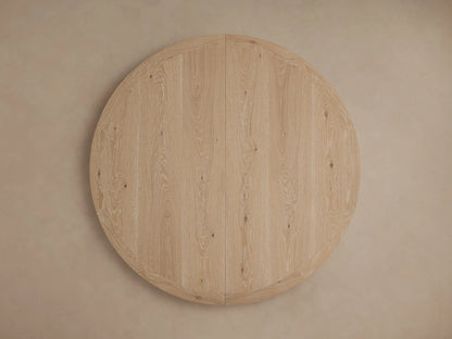 Angled close-up of Leighton Extension Dining Table's light oak veneer surface with visible grain, rounded edge & a subtle seam.