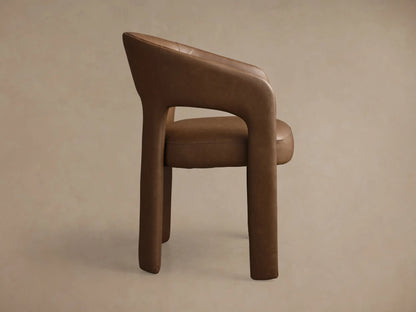 Close-up of the rich brown Lilette Faux Leather Dining Arm Chair, highlighting its curved back, integrated armrests, and faux leather texture.