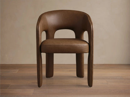 Side profile of the brown Lilette Faux Leather Dining Arm Chair, showing its curved back and integrated armrests.