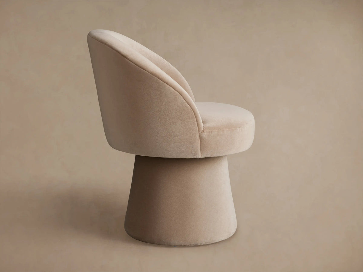 Lindsay Swivel Dining Chair in beige fabric, featuring a curved backrest and cushioned seat, angled view showing fabric texture.