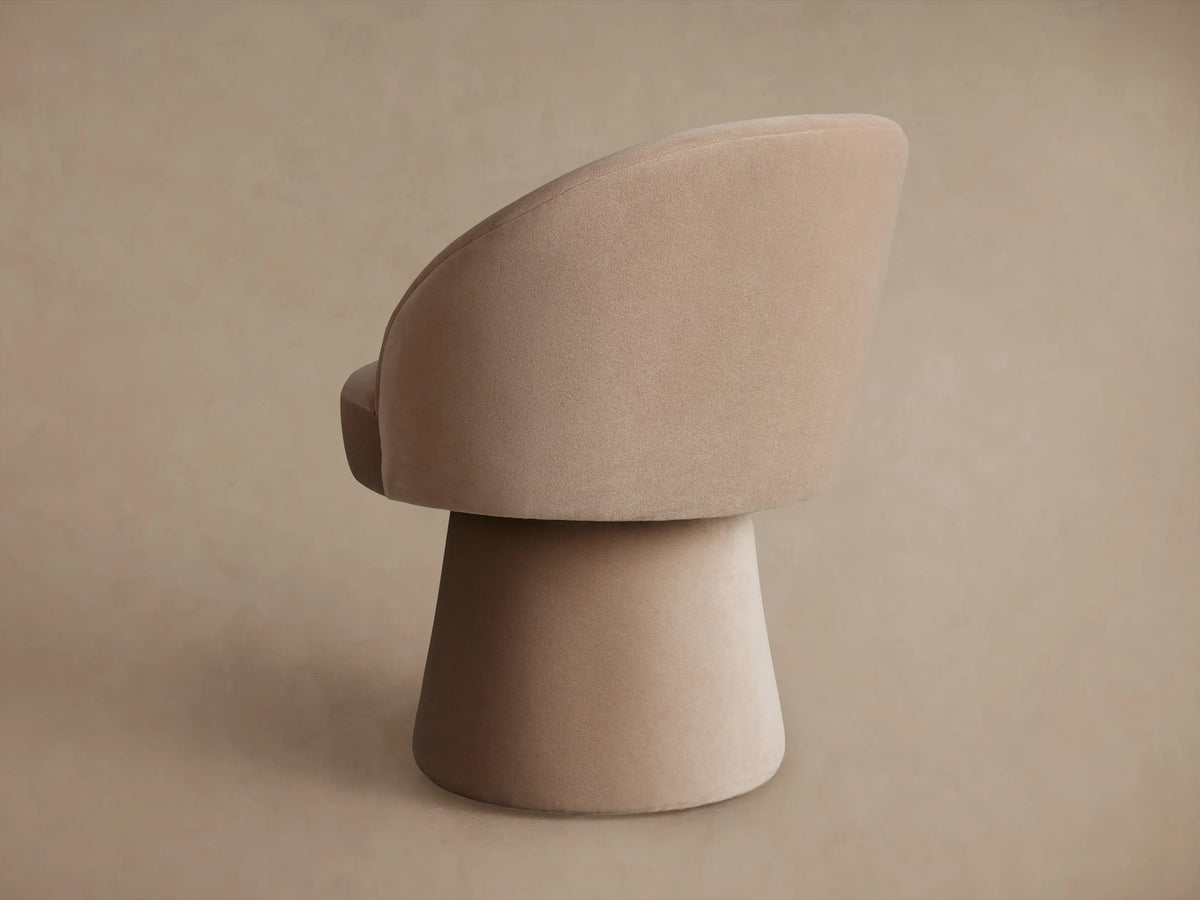 Lindsay Swivel Dining Chair in beige fabric, side view. Features a round seat, curved backrest, and conical base.