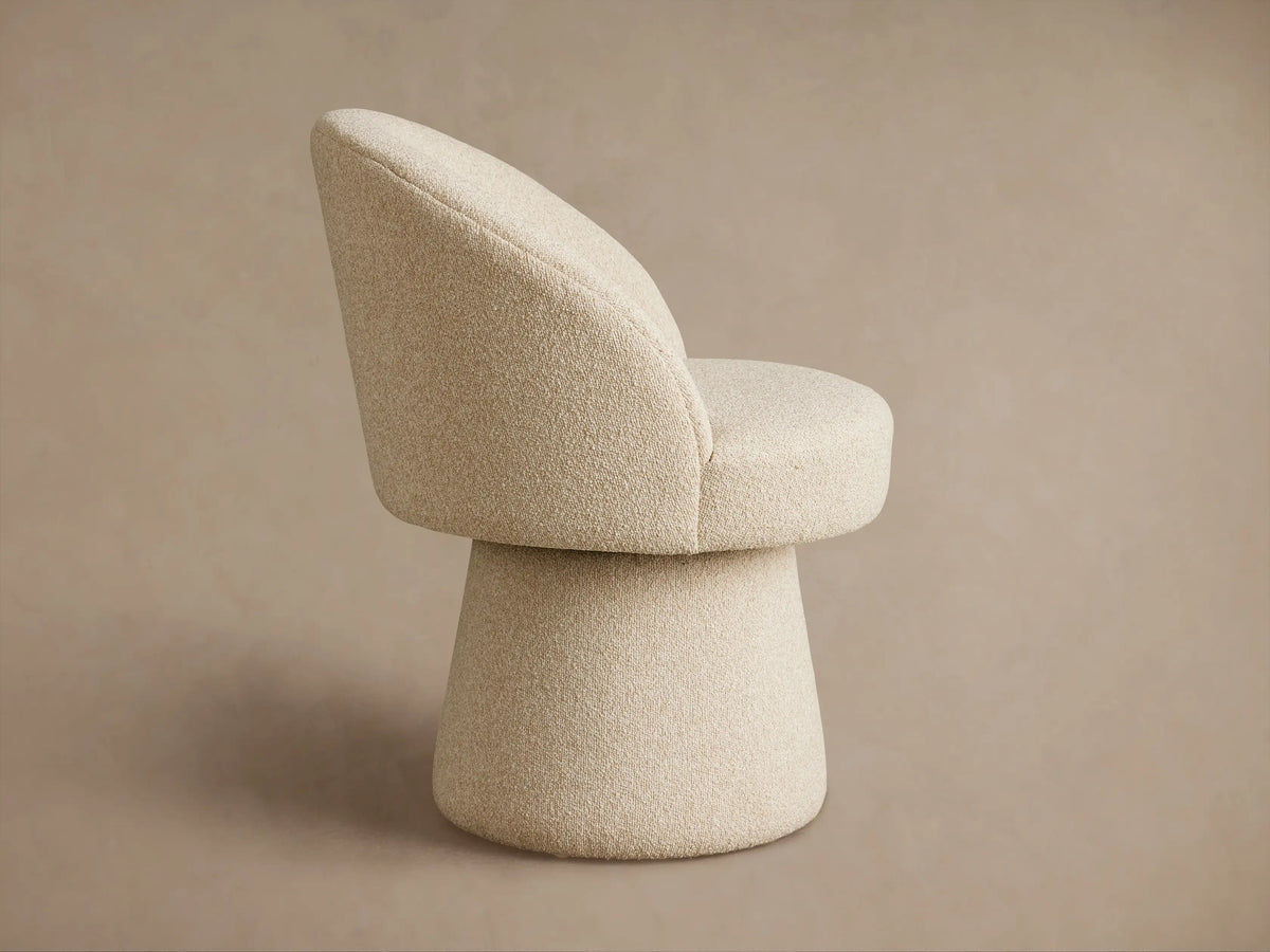 Close-up of the Lindsay Swivel Dining Chair showcasing a textured beige fabric with a looped, nubby surface on the upholstery.