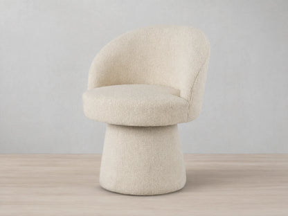 Lindsay Swivel Dining Chair in beige fabric, featuring a curved backrest and round cushioned seat on a tapered base, on a wooden floor.