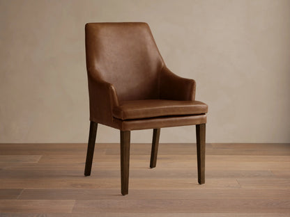 Lunden Faux Leather Dining Arm Chair in brown, featuring a gently curved backrest and armrests, on wooden legs.