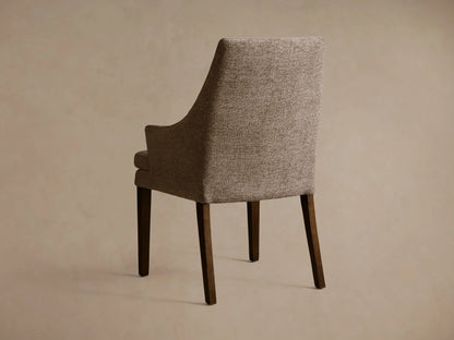 Lunden Dining Arm Chair with textured brown fabric, elegant curved backrest, and armrest, shown in close-up view.