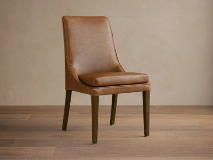 Lunden Dining Side Chair in brown leather with a gently curved backrest and cushioned seat, supported by wooden legs.