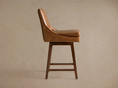 Lunden Faux Leather Swivel Stool with brown faux leather upholstery, curved backrest, and wooden legs with footrest, angled view.