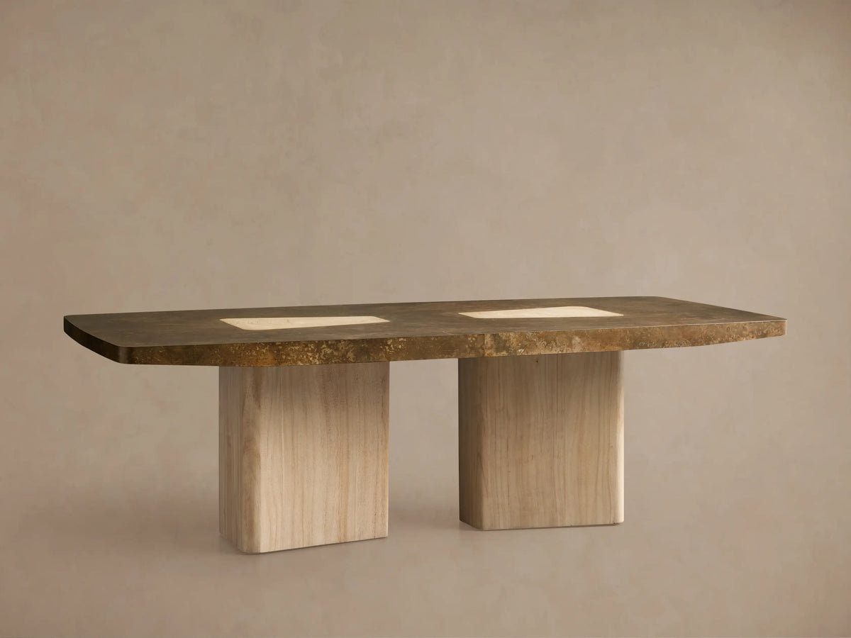 Marea Dining Table, a long dark oxidized aluminum top resting on two light guanacaste wood veneer pedestals, surrounded by chairs.