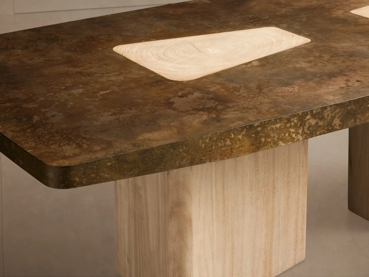 Marea Dining Table: Rectangular dark oxidized aluminum top with light rectangular inlays, supported by two light wood block bases.
