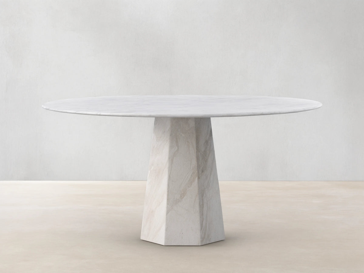 Round light beige marble Modena Dining Table with a geometric pedestal base, centered on a wooden floor.