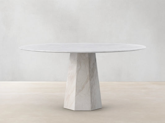 Round light beige marble Modena Dining Table with a geometric pedestal base, centered on a wooden floor.