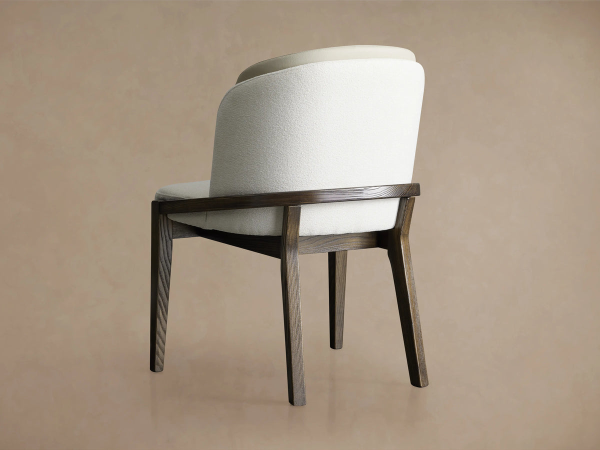 Mena Dining Chair with solid ash wood frame in Vesuvio Black finish, upholstered in beige faux leather and white fabric, shown from the back.