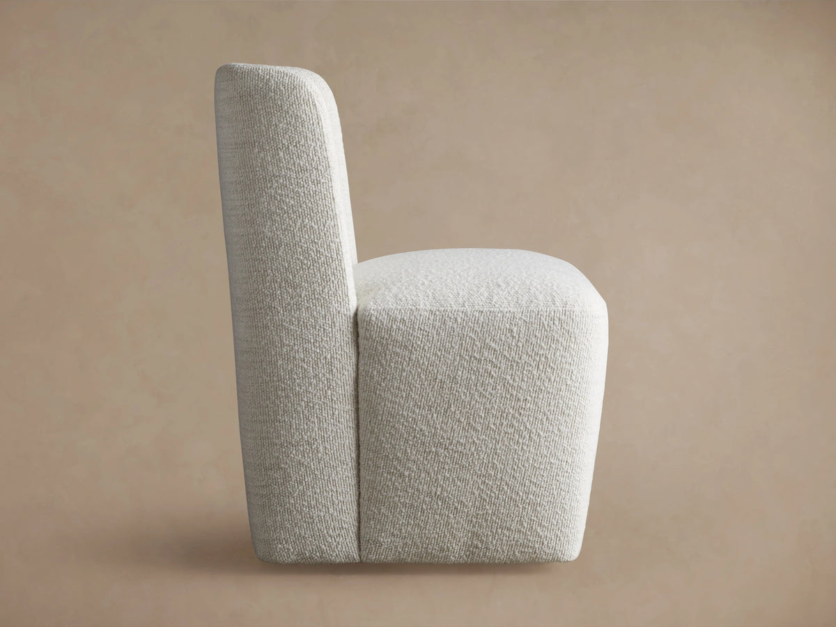 Mila Dining Chair in light fabric, viewed from the back, showing its tall, rectangular backrest and textured finish.