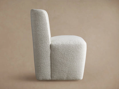 Mila Dining Chair in light fabric, viewed from the back, showing its tall, rectangular backrest and textured finish.