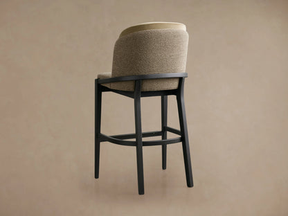 Mena Stool with beige faux leather upholstered back and taupe seat on a solid black ash wood frame, placed on wooden flooring.