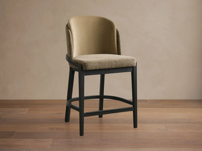 Mena Stool with beige faux leather backrest, taupe fabric seat, and black ash wood frame on wooden floor.