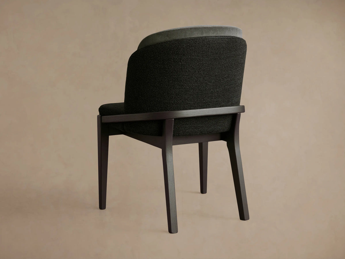 Mena Dining Chair, dark ash wood frame, layered backrest with dark & light grey fabrics, seen from behind, angled.