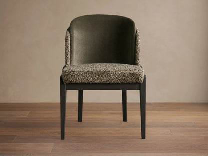 Front view of Mena Dining Chair. Dark green velvet back, multi-tone textured fabric seat and outer arms, dark tapered wood frame.
