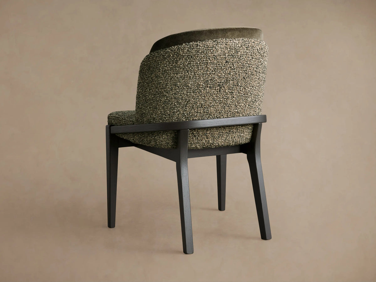 Mena Dining Chair with dark ash wood frame & tapered legs, angled rear. Curved back features green textured and dark velvet fabrics.