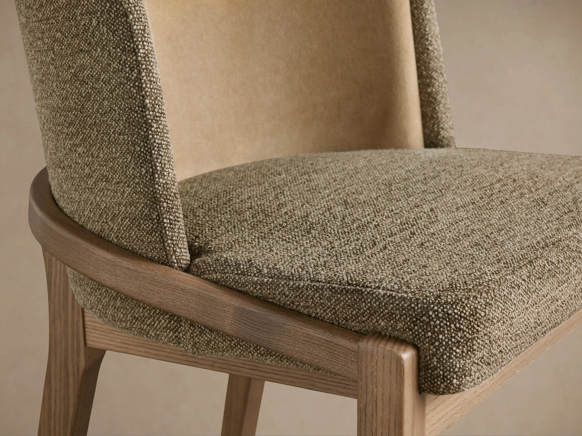 Close-up of Mena Dining Chair's textured brown-green seat and layered back with a lighter beige inner and curved light wood frame.