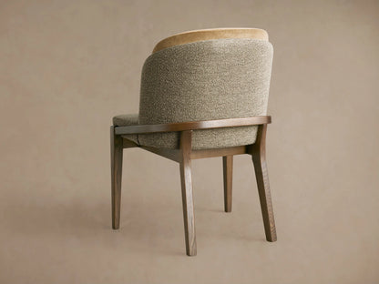 Mena Dining Chair, angled rear view. Dark ash wood frame, textured grey-brown and light tan layered backrest. Tapered legs.