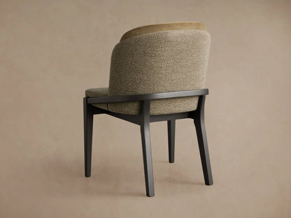 Close-up of a chair's side, showing textured greige upholstery, dark wood frame, and a curved armrest.