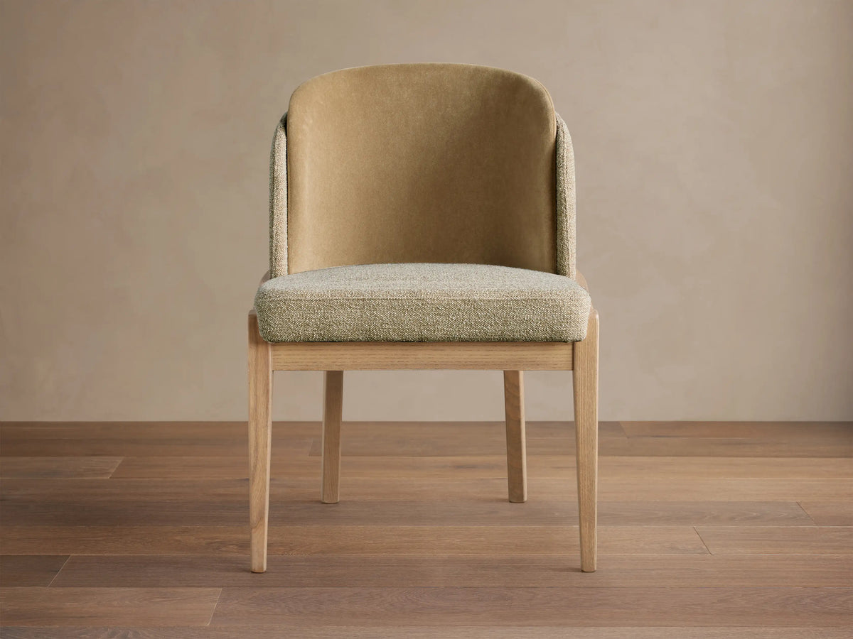 Mena Dining Chair, light wood frame, curved backrest with tan fabric, and textured green-beige seat, front view.