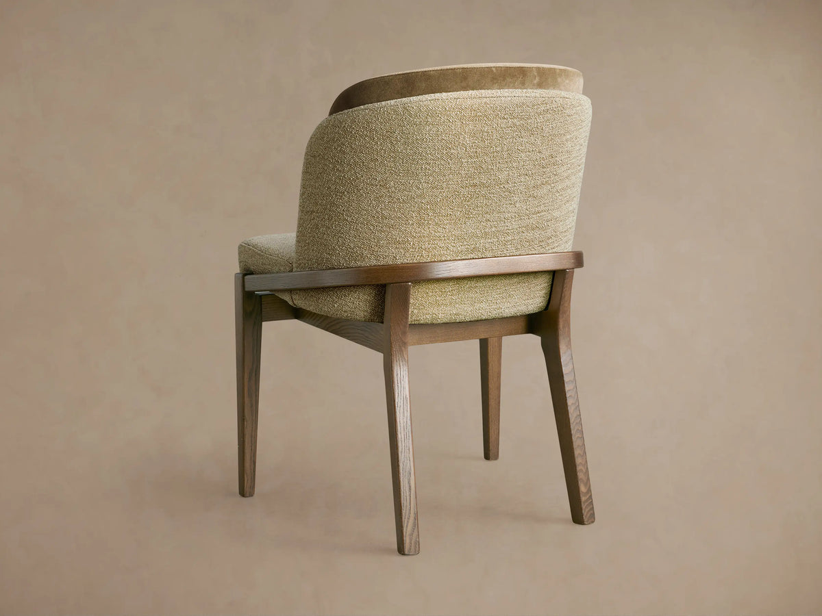 Mena Dining Chair, angled back. Dark ash wood frame, tapered legs. Layered backrest: textured light olive & smooth darker brown fabric.