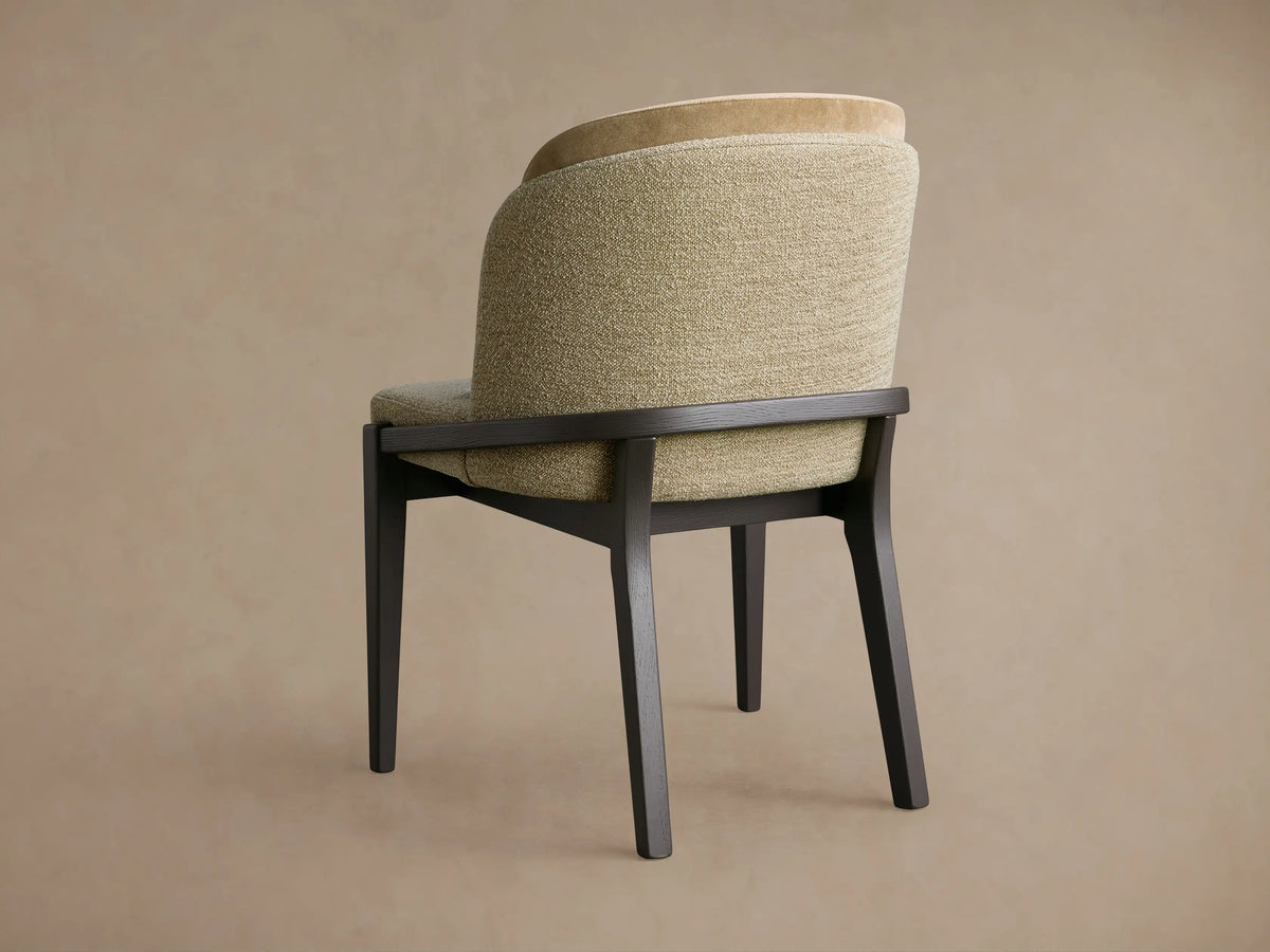 Mena Dining Chair, 3/4 back view. Dark ash wood frame, tapered legs. Layered backrest in textured olive fabric & light tan.