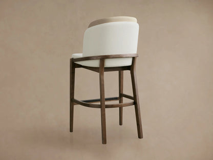 Angled close-up of Mena Stool, featuring a cream textured fabric seat, layered backrest, and dark ash wood frame.
