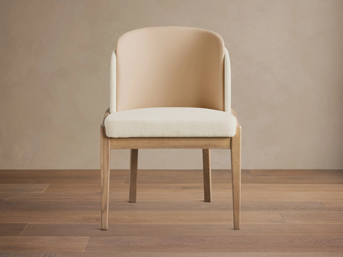Mena Dining Chair: Ash wood frame, cream fabric seat, and a two-tone beige and cream layered backrest on a wooden floor.