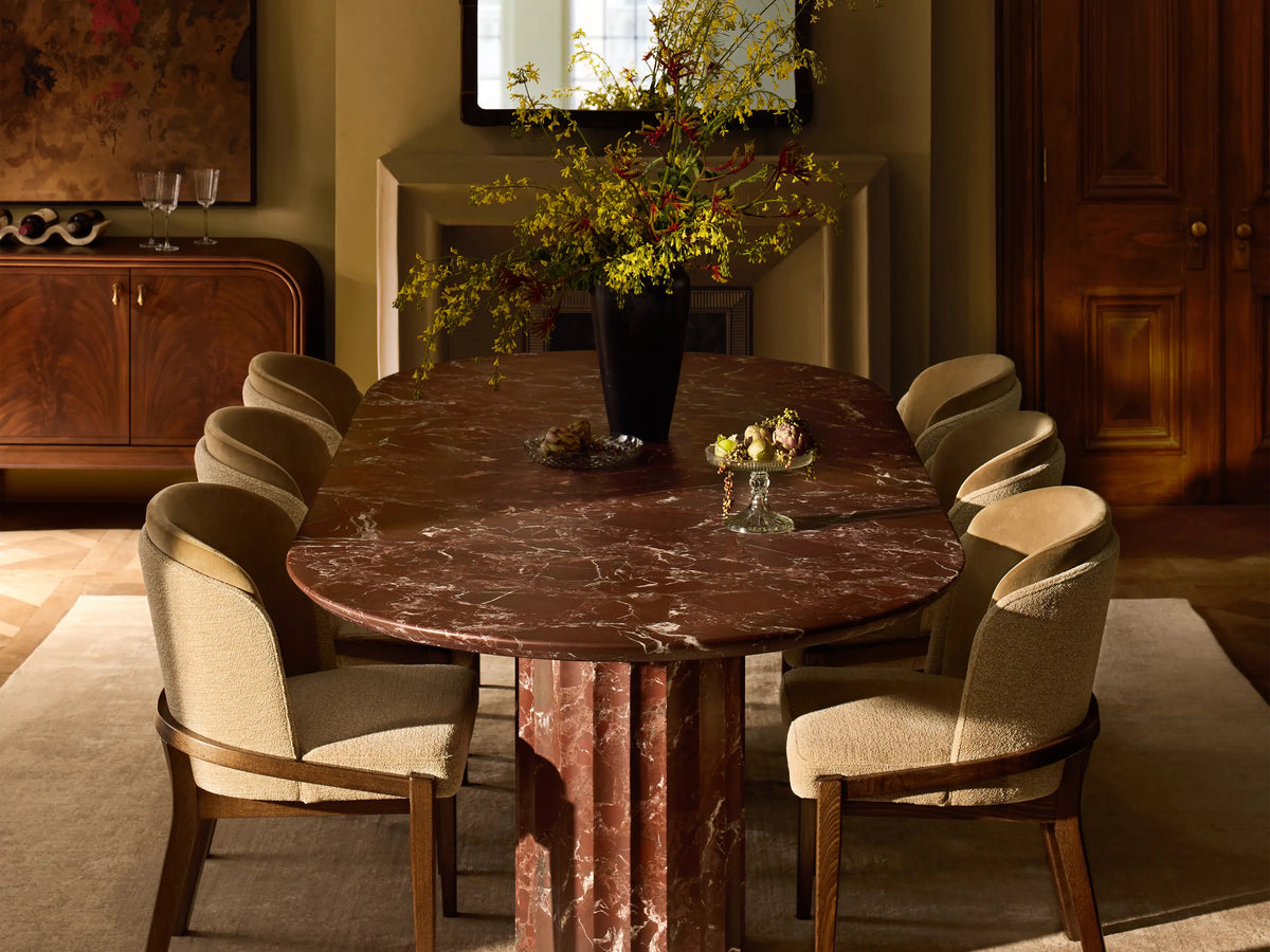 Mena Dining Chair: Dark ash frame with layered beige fabric backrest and light cream seat, angled on a wood floor.